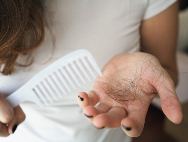 Une femme tient une poignée de cheveux dans sa main